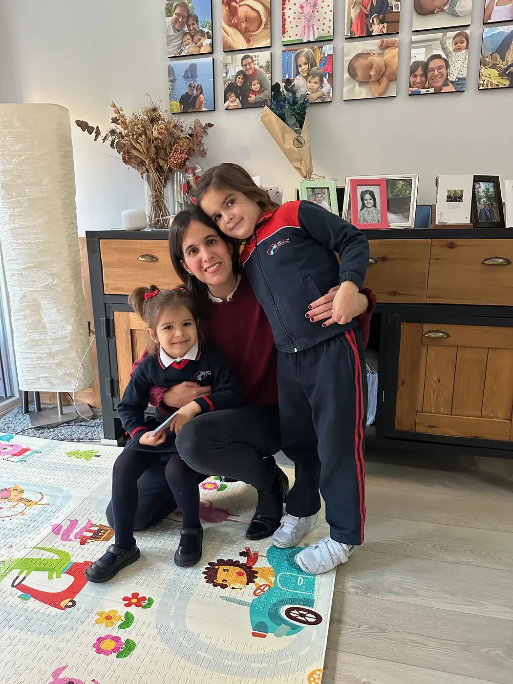 Anna abrazada a sus dos hijas en casa