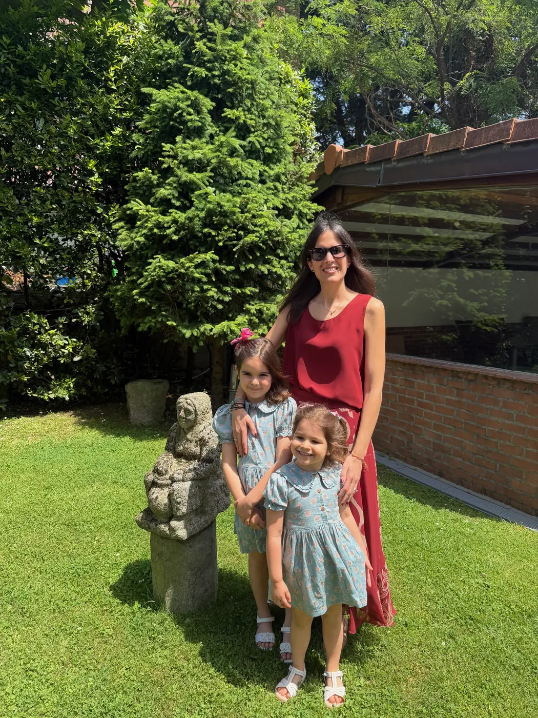 Anna con sus hijas en un jardín